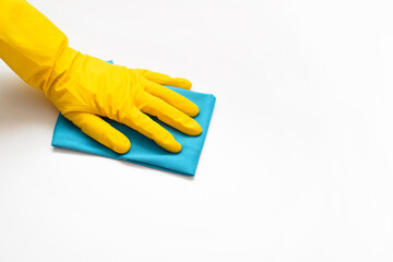 House cleaning, housework concept. Close-up of hand in yellow glove with rag wiping white clean surface, top view