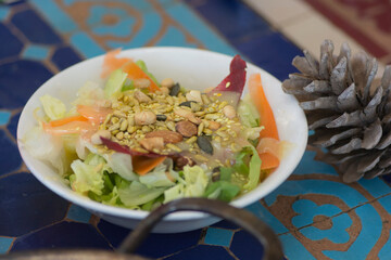 Colorful fresh salad with lettuce, nuts and slices of carrot and beetroot