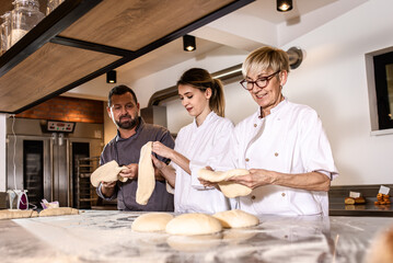Bakers preparing dough for baking bread in modern manufacturing.