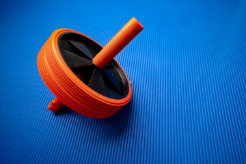 Abs roll out exercise fitness wheel on blue background