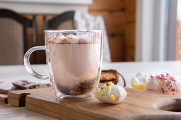 Hot drink with marshmallows on a wooden table.