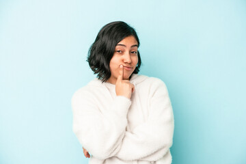 Young latin woman isolated on blue background contemplating, planning a strategy, thinking about the way of a business.