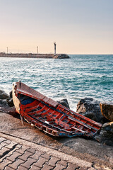 Old broken wooden fishing boat on the sea shore