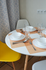  Served white round table in Scandinavian style.