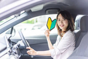 初心者マークを持った若い女性ドライバー