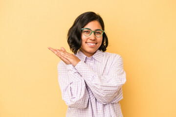 Young latin woman isolated on yellow background feeling energetic and comfortable, rubbing hands confident.