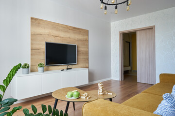 TV area with wooden decor and a yellow Scandinavian-style sofa