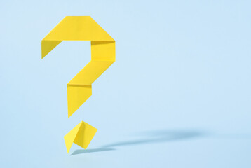 Floating yellow origami question mark with drop shadow