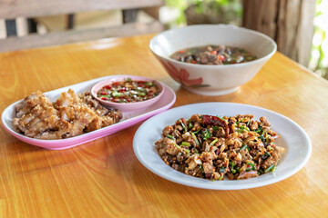 spicy minced meat with mixed vegetables and spicy soup on table