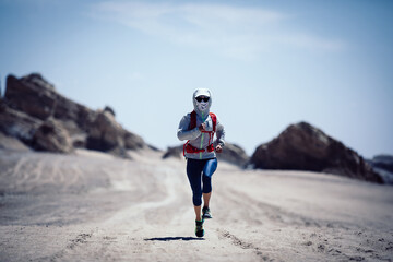 Fototapeta na wymiar Fitness woman trail runner cross country running on sand desert