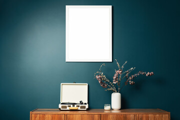 Blank picture frame mockup on green wall. View of modern scandinavian style interior with artwork mock up on wall