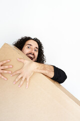 Vertical shot of Black Friday sale concept where young smiling man holds to new king size tv box