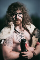 Medieval warrior berserk Viking portrait with tattoo on skin, cuts on body and braids in hair with weapons to attacks enemy. Concept historical photo