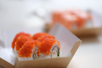 Fresh sushi in a white cardboard box, close-up