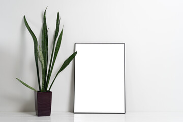 Blank canvas frame mockup on white wall. View of modern scandinavian style interior with artwork mock up on wall