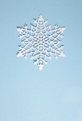 White snowflake on a soft blue background. Minimal creative concept. Flat lay idea.