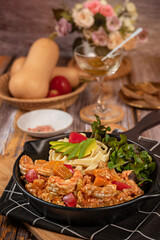 Spaghetti with prawns and vegetables on white dish