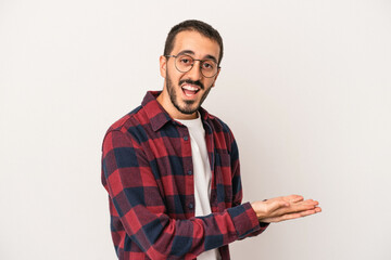 Young caucasian man isolated on white background holding a copy space on a palm.