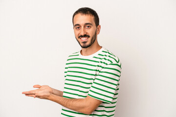 Young caucasian man isolated on white background holding a copy space on a palm.