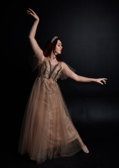 Full length  portrait of red haired  girl wearing a creamy fantasy gown like a fairy goddess...