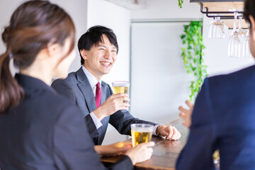 お酒を飲みながら話すビジネスパーソン