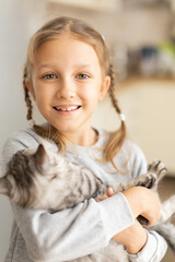 Child girl holding a fluffy kitten