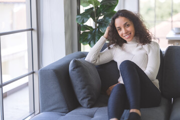 Portrait of beautiful young black woman relaxing and smile on sofa in holiday at home. business women and freelancers working from home to spread coronavirus covid-19