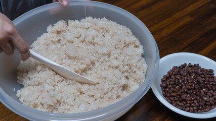 日本の料理・赤飯を作る。小豆と米を混ぜる。”Festive red rice”