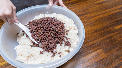 日本の料理・赤飯を作る。小豆と米を混ぜる。”Festive red rice”