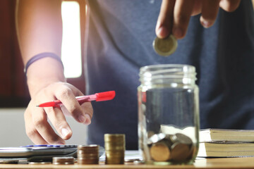 businessman holding coins putting in glass. concept saving money for finance accounting.