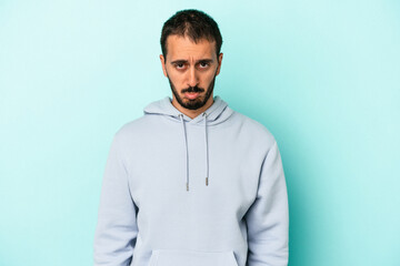 Young caucasian man isolated on blue background sad, serious face, feeling miserable and displeased.