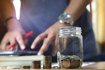 Men's hand put coin in glass jar.Money management planing and financial concept.