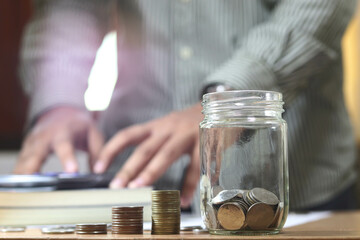 Men's hand put coin in glass jar.Money management planing and financial concept.