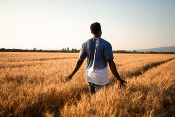 Young farmer standing in the middle of the field