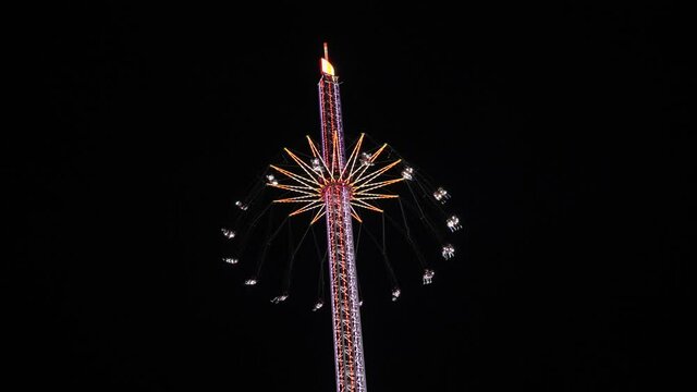 Tower Swinger Ride In Amusement Park at night at anual funfair