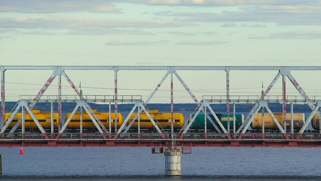 A train of fuel tanks moves on a metal girder bridge across the river in the city of Syzran, Russia, close up