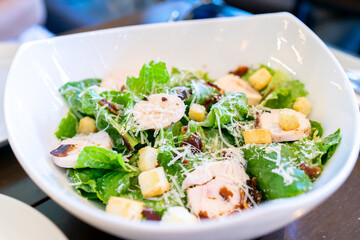 Salad with checken and beacon in white bowl