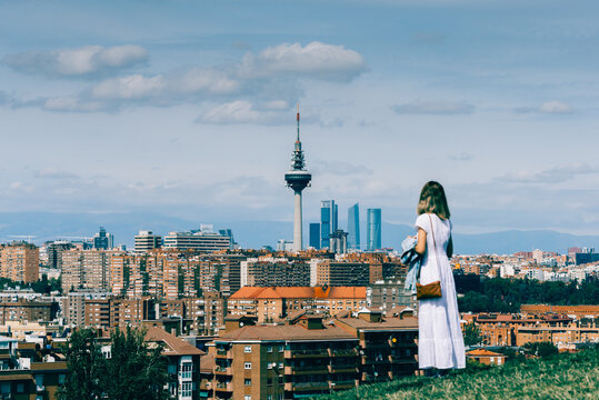 Girl in white dress enjoying Madrid view from Siete Tetas Park