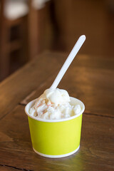 Close up of Strawberry cheese cake ice cream in the light green paper cup.