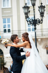 Naklejka premium Happy newlywed bride and groom in the old city