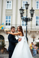 Naklejka premium Happy newlywed bride and groom in the old city