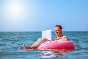 Work from anywhere and remote occupation concept. Businessman freelancer working with laptop computer on inflatable ring in Tropical sea.