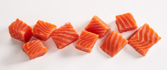 Closeup shot of raw fresh salmon fillet cut in cubes placed on white background