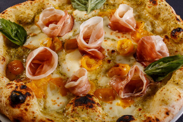 Pizza napoletana con mozzarella, pomodorini gialli, prosciutto crudo e basilico fresco