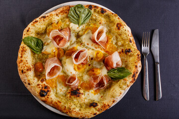 Pizza napoletana con mozzarella, pomodorini gialli, prosciutto crudo e basilico fresco