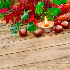 Fototapeta na wymiar Dekoration im Herbst und Kerze mit Kastanien auf Holz