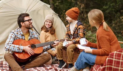 Happy parents and kids enjoying great family camping trip in nature