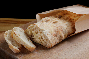 Ciabatta. Fresh italian ciabatta bread with herbs, Fresh ciabatta sliced on a wooden board - obrazy, fototapety, plakaty