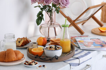 Tray with tasty breakfast on white table in morning