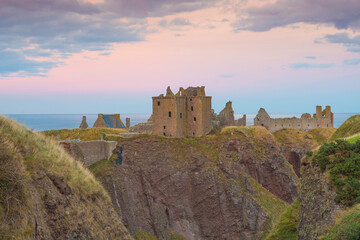 Fototapeta premium Dunnottar Castle is a ruined medieval fortress located upon a rocky headland on the north-eastern coast of Scotland south of Stonehaven. Sunset Evening